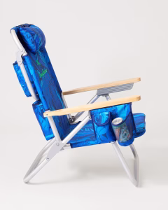 Side view of blue Tommy Bahama beach chair with wooden armrests and storage pockets